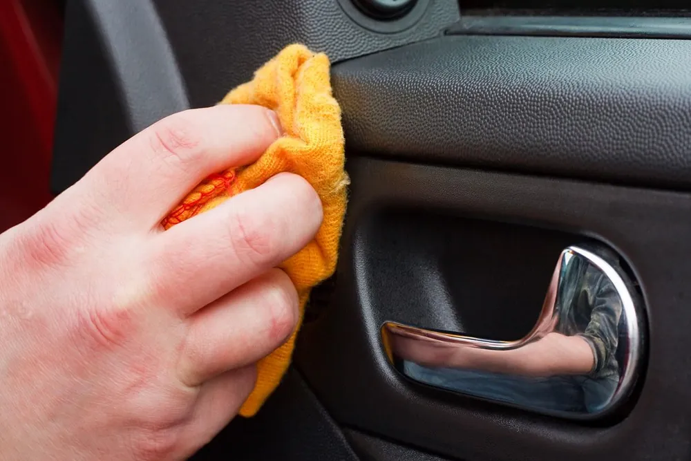 Limpieza del panel de la puerta del auto con paño de microfibra: lavado de autos interior y exterior