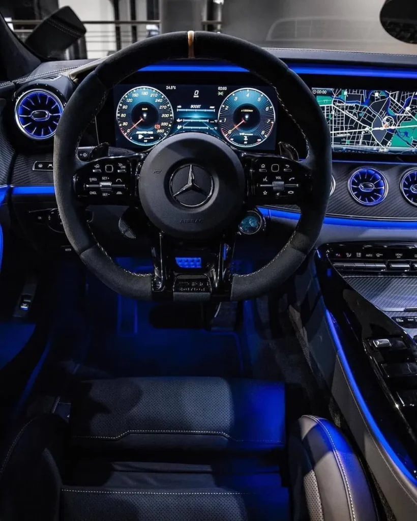Volante forrado y tablero con iluminación azul en un interior limpio
